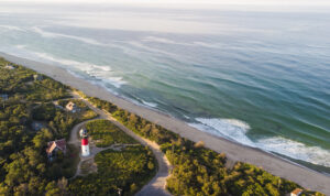 Nauset Beach mit Nauset Light, umgeben von Sanddünen, blauem Himmel und der rauen Atlantikküste.