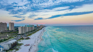 Blick auf den weißen Sandstrand und das türkisfarbene Wasser von Destin Beach an Floridas Golfküste.