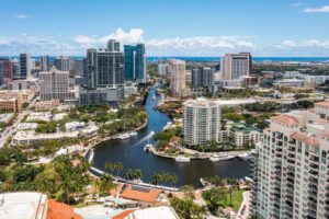 Blick auf Downtown Fort Lauderdale mit Hochhäusern, Wasserkanälen, Yachten und dem Atlantik am Horizont.
