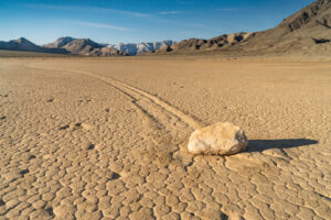 Racetrack Playa im Death Valley: Stein mit Schleifspur auf trockenem Seebett