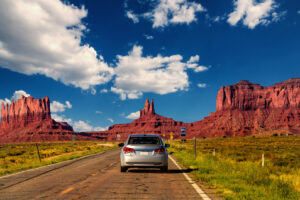 Auto auf einer Straße durch das Monument Valley an der Grenze von Arizona und Utah.
