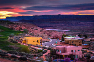 Blick auf Page in Arizona bei Sonnenuntergang mit Gebäuden und Felslandschaft im Hintergrund.