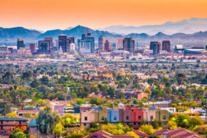 Skyline von Phoenix in Arizona in der Abenddämmerung mit Bergen im Hintergrund.