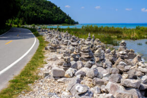 Küstenweg auf Mackinac Island mit Steinmännchen, Felsen und blauem Wasser