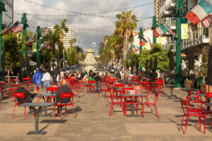 Piazza della Famiglia in Little Italy San Diego mit roten Stühlen, Palmen und Flaggen