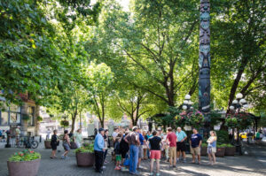 Besuchergruppe am Totempfahl im Pioneer Square in Seattle