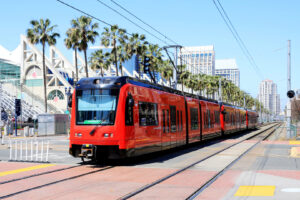 Roter San Diego Trolley vor dem Convention Center und Palmen in Downtown San Diego