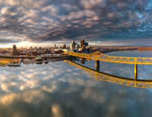 Luftaufnahme der Skyline von Louisville mit gelber Brücke über den Ohio River und dramatischem Wolkenhimmel