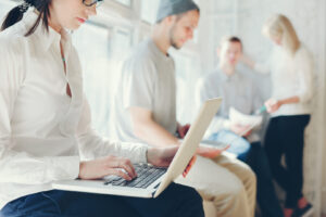 Menschen arbeiten in einem Loftbüro mit Laptops und Unterlagen