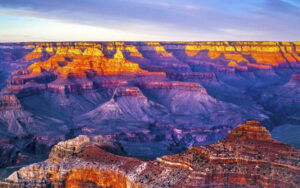 Blick vom South Rim über die gestaffelten Felsformationen des Grand Canyon im warmen Sonnenlicht