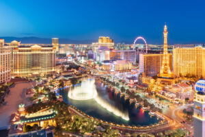 Las Vegas Strip am Abend mit beleuchteten Bellagio-Fontänen und dem Eiffelturm-Nachbau des Paris Las Vegas