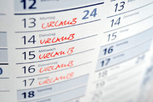 Kalender mit mehreren handschriftlichen Urlaubseinträgen in Rot