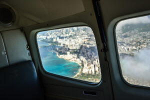 Blick durch Flugzeugfenster auf Honolulu und die Küste von Oʻahu
