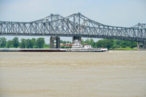 Schubboot mit Lastkähnen auf dem Mississippi vor der Brücke bei Natchez