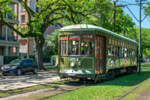 Grüne Straßenbahn der St. Charles Line unter Bäumen in New Orleans