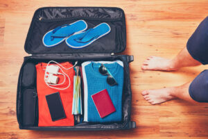 Mann packt Handy und Reisepass für eine Reise
